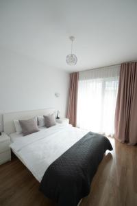 a bedroom with a large white bed and a window at Central Residence in Baia Mare +33 photos