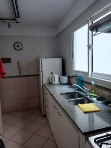 a kitchen with a sink and a refrigerator at Nice apartment in good location in Buenos Aires +1 photo