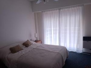 a bedroom with a bed and a large window at Nice apartment in good location in Buenos Aires