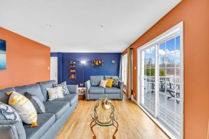 a living room with a gray couch and an orange wall at Serene 7BR Haven by the Lake home in Sullivan