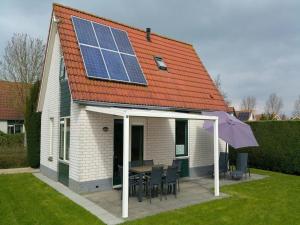 a house with a table and a roof with solar panels at Holiday Home near Beach in Strandpark in Breskens