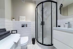 Un baño blanco con ducha y WC. en Cosy Apartment Połczyńska 6, en Bydgoszcz