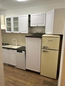 a kitchen with white cabinets and a white refrigerator at House Sunshine in Mrljane