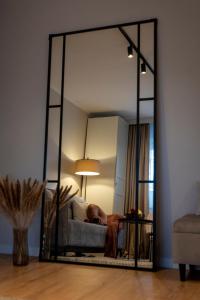 espejo en la sala de estar con sofá y lámpara en Cosy Apartment Połczyńska 6, en Bydgoszcz