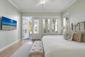 a bedroom with a bed and a tv on the wall at Seeking Sunsets 30A in Rosemary Beach