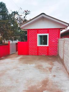 a red brick house with a red wall at Le case Rosse in Itapoa
