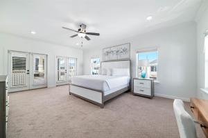 a white bedroom with a bed and a ceiling fan at Endless Summer in Orange Beach