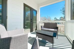 a screened in porch with chairs and a table at Endless Summer in Orange Beach