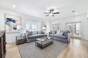 a living room with two couches and a ceiling fan at Endless Summer in Orange Beach