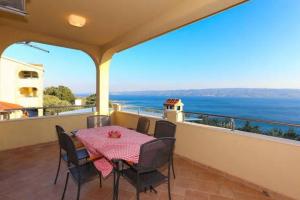 a table and chairs on a balcony with a view of the ocean at Villa Casa with indoor pool in Krilo