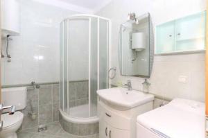 a white bathroom with a sink and a shower at Villa Casa with indoor pool in Krilo +26 photos