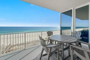 Una mesa y sillas en un balcón con vista al mar. en Mediterranean West Unit 601W, en Pensacola