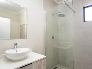 a white bathroom with a sink and a shower at Binbin Serenity Suite in Midrand +7 photos