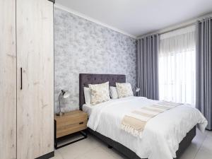 a bedroom with a large bed and a window at Binbin Serenity Suite in Midrand