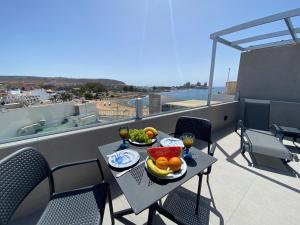 a table with bowls of fruit on a balcony at Alaram Holidays House in Arguineguín