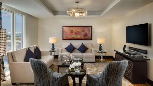 a living room with a couch and a tv at Kempinski Hotel Mall of the Emirates, Dubai in Dubai