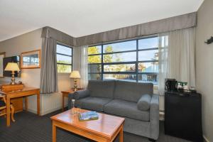 a living room with a couch and a large window at Listel Whistler, a Coast Hotel in Whistler