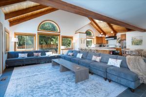 a living room with blue couches and a table at Greystone Manor- HUGE home with sleeping for 21 in Oakhurst