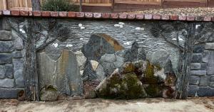 a stone wall with a bunch of rocks at Greystone Manor- HUGE home with sleeping for 21 in Oakhurst +70 photos