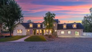 a house with a driveway in front of a sunset at Cedar Creek Lodge with POOL/hot tub/sleeps 24 in Oakhurst +70 photos