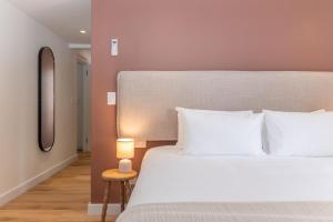 a bedroom with a large white bed and a lamp at Maison la Bruyere, 4 bedroom villa - pool, airco & hottub in Franschhoek