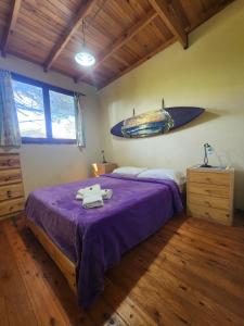 Un dormitorio con una cama con una tabla de surf colgada en la pared. en La Lucinda - Campo y mar, en Chapadmalal 58 fotos más