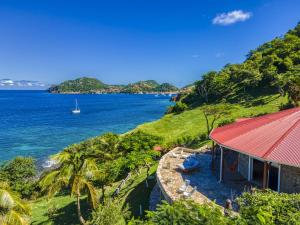 a house on a hill next to the ocean at Vue mer, accès plage et ponton privé - SATH02 in Terre-de-Haut