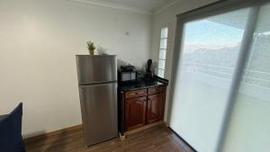 a kitchen with a stainless steel refrigerator next to a window at Quinta do Araújo - GuestHouses in Câmara de Lobos