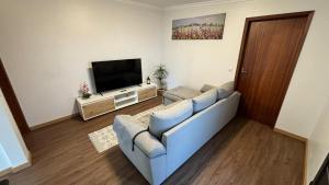 a living room with a couch and a television at Quinta do Araújo - GuestHouses in Câmara de Lobos
