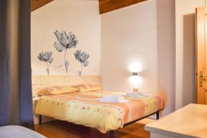 a bedroom with a bed with flowers on the wall at Dal Carniel in Aldeno