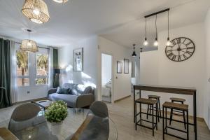 a living room with a table and a living room with a clock at Laguna Home in Ayamonte
