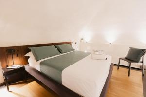 une chambre avec un grand lit et une chaise dans l'établissement Fondaco dei Longobardi, à Trani