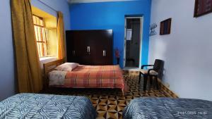 ein Schlafzimmer mit zwei Betten und einer blauen Wand in der Unterkunft Casa El Capulí in Cajamarca