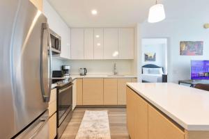 Una cocina con gabinetes blancos y un refrigerador de acero inoxidable. en Luxury Apt Downtown, en Boston