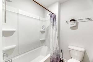 a white bathroom with a shower and a toilet at 17 Mi to Dtwn Nashville Family-Friendly Gem in Antioch +16 photos