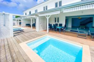 een zwembad op een terras met een huis bij Mqro11 4 et 1 in Le Robert