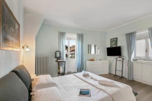 a bedroom with a white bed and a television at La Lanterna Swimming Pool Retreat - Happy Rentals in Gignese