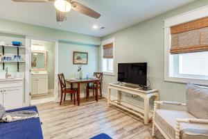 a living room with a table and a tv at Walk to Beach Apt with Private Hot Tub! in Kill Devil Hills