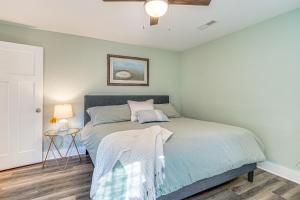a bedroom with a bed and a table with a lamp at Walk to Beach Apt with Private Hot Tub! in Kill Devil Hills