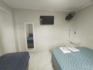 a bedroom with a bed and a tv on the wall at Hotel Anacleto in São Paulo