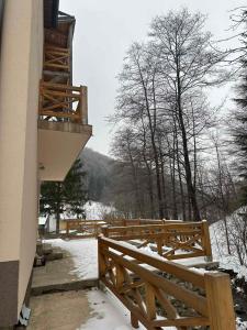 a balcony with a wooden fence and snow on the ground at Lily Apartmani Brzece in Brzeće