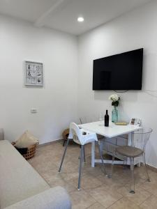 a living room with a white table and a tv on the wall at La Bella Vita Bergamo with free private parking in Bergamo