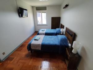 a bedroom with two beds and a television in it at Depto calle huérfanos, Santiago in Santiago