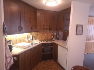 a kitchen with wooden cabinets and a stove top oven at Ski fahren-Schneeschuhwandern-Langlauf inkl Hallenbad in Luzein +25 photos