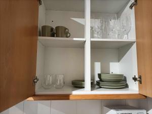 a white cabinet with plates and glasses in it at Apartamentos São Sebastião in Évora