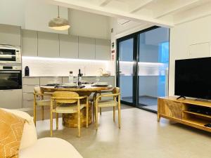a kitchen and dining room with a table and a television at Casa Arrifana in Carrapateira