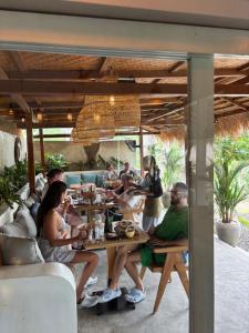 a group of people sitting at a table in a restaurant at kaje cottage & restaurant in Nusa Penida