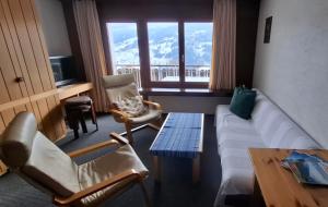 a living room with a couch and chairs and a table at Ski fahren-Schneeschuhwandern-Langlauf inkl Hallenbad in Luzein