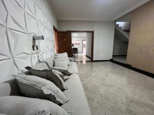a living room with a couch with pillows on it at Angel Hospedagem Itapuã in Vila Velha +60 photos