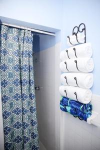a bathroom with blue and white towels and a shower at Tangerine Sunsets Alta Vista Studio One in Nassau